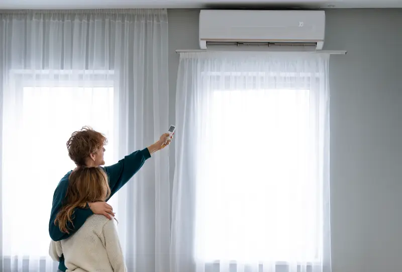 Domownicy regulujący klimatyzację jako element systemu wentylacji w domu